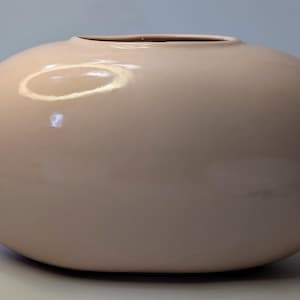 Peut inclure: Un grand vase ovale lisse avec un glacis rose clair.