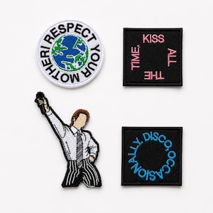 May include: Four embroidered patches: a circular patch with a blue and green Earth and the text RESPECT YOUR MOTHER, a square black patch with pink text KISS ALL THE TIME, a figure in a white shirt and striped pants, and a square black patch with blue text DISCO OCCASIONALLY.