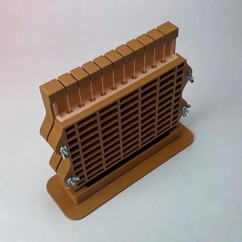 May include: A brown wooden tool with a grid-like structure and a series of vertical slots. The tool has a rectangular base and is secured with metal wing nuts. The top features a row of small, square blocks.