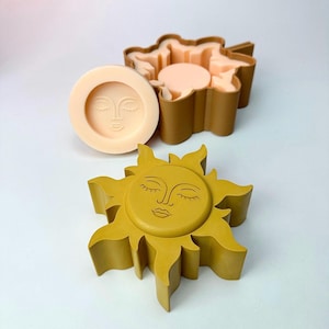Puede incluir: Un conjunto de moldes con forma de sol y redondos con un diseño de rostro. Los moldes son en tonos amarillo, marrón y melocotón. El molde con forma de sol tiene un rostro detallado con ojos cerrados y boca sonriente.