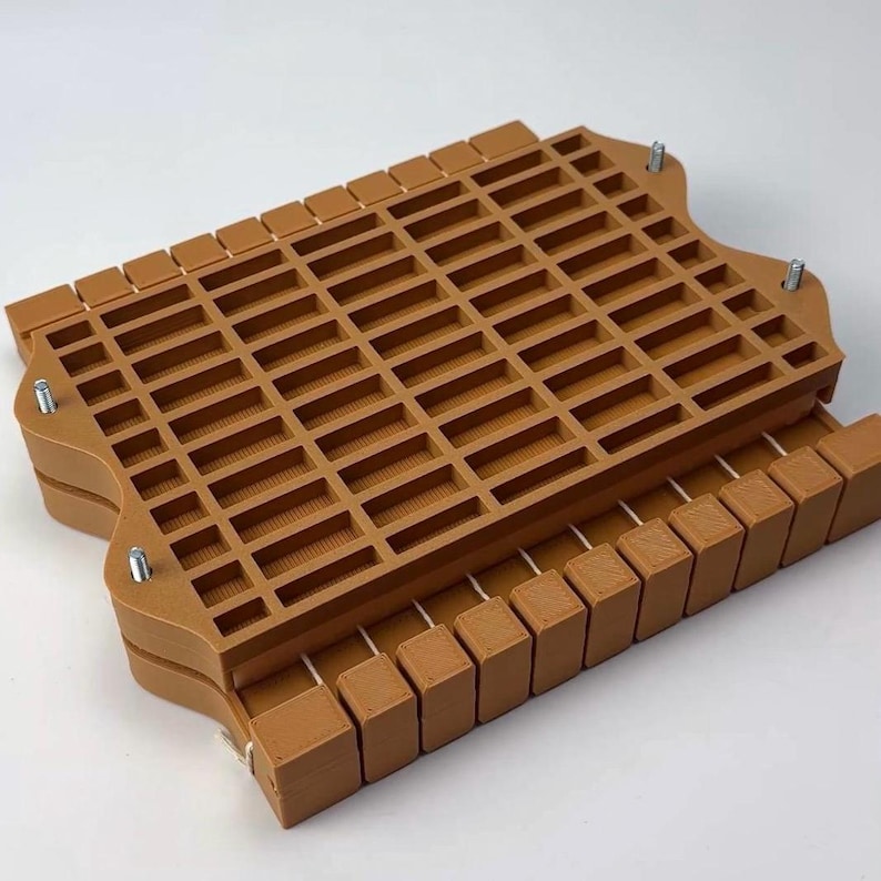 May include: A brown, rectangular, multi-compartment organizer with a grid-like top. The organizer has a tray-like design with a series of small, rectangular openings. Metal screws secure the top and bottom sections. The item is designed for organizing small items.