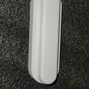 May include: A white plastic wall mount with a rounded rectangular shape.