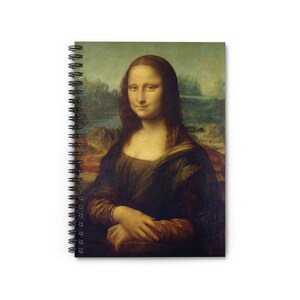 Puede incluir: Cuaderno con espiral con la pintura de la Mona Lisa de Leonardo da Vinci. La portada muestra el icónico retrato en sus colores originales, con un fondo de paisaje. El cuaderno tiene una encuadernación en espiral negra.