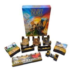 Könnte beinhalten: Eine Brettspielbox mit einer Fantasy-Illustration von zwei Figuren, eine in grün-goldener Rüstung und die andere in schwarzer Rüstung. Die Box ist mit "Der Herr der Ringe Duell: Mittelerde" betitelt. Das Spiel enthält eine Vielzahl von Komponenten, darunter Karten, Würfel und Spielsteine.