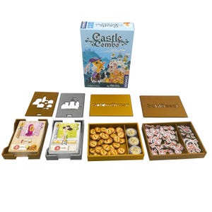 Könnte beinhalten: Das Brettspiel "Castle Combo" mit einer Schachtel mit Cartoon-Illustrationen eines Schlosses. Das Spiel enthält Karten, Spielsteine und Tabletts. Die Spielsteine sind in Braun-, Gold- und Weißtönen gehalten.