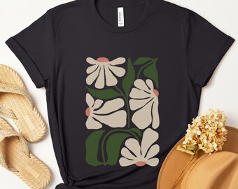 May include: Black t-shirt with a white and green floral design. The flowers are stylized and have a retro feel.