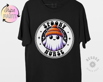 Może przedstawiać: Czarny T-shirt z białym kołem graficznym przedstawiającym kreskówkowego ducha w pomarańczowo-białym berecie. Wewnątrz koła znajduje się napis "Spooky Nurse".