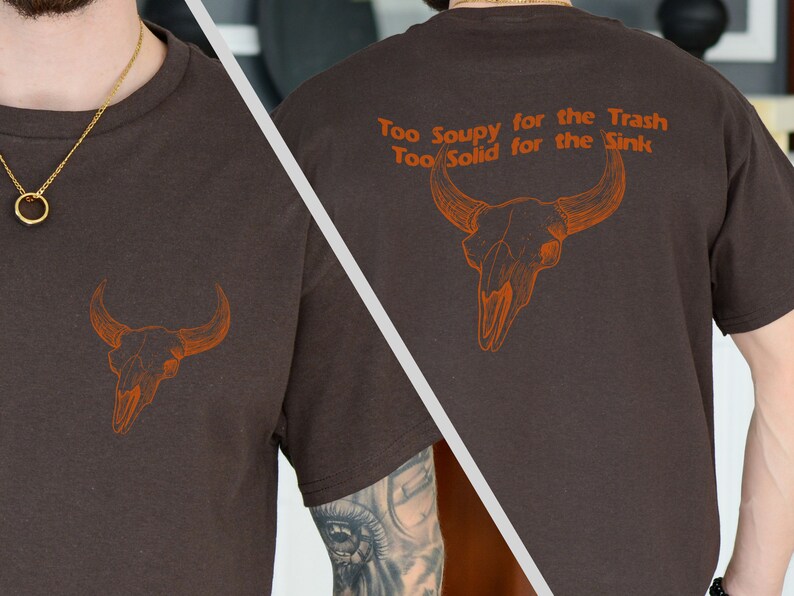 May include: Brown t-shirt with a brown bull skull graphic and the text "Too Soupy for the Trash Too Solid for the Sink".