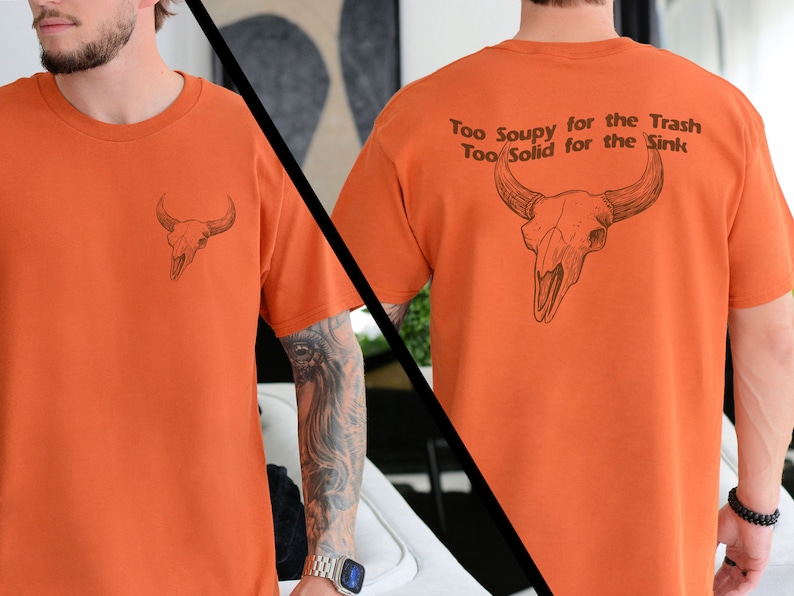 May include: Orange t-shirt with a bull skull graphic on the front and the text "Too Soupy for the Trash Too Solid for the Sink" on the back.
