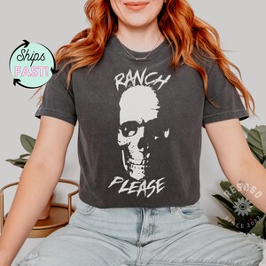 May include: A black cropped t-shirt with a white skull graphic and the text "Ranch Please".