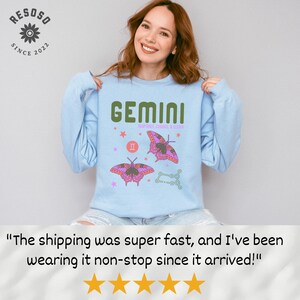 May include: Light blue sweatshirt with a graphic print of a butterfly and the text "GEMINI" in green. The graphic also includes the astrological symbol for Gemini and the text "COMPATIBLE SIGNS: CANCER & LIBRA".