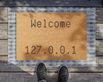 May include: A brown welcome mat with a white border and the text "Welcome 127.0.0.1" on it.