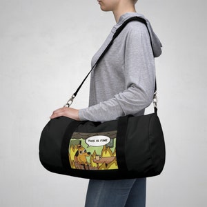 May include: Black duffel bag with a white and yellow graphic of a dog sitting in a burning room with the text "This is fine".
