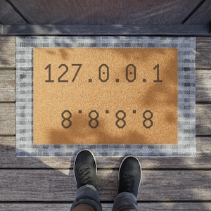May include: A brown doormat with a white border and black text that reads "127.0.0.1 8.8.8.8.8".