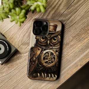 Puede incluir: Una funda para teléfono con un diseño de búho steampunk. El búho está hecho de engranajes y está usando un sombrero de copa. La funda es marrón y tiene un recorte de cámara negro.