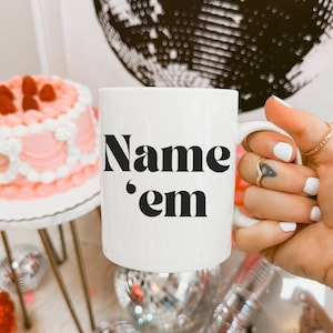 Puede incluir: Taza de cerámica blanca con texto negro que dice "Name 'em".