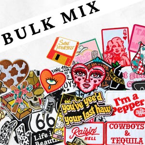 May include: A collection of embroidered patches with various designs, including a heart-shaped face, a cowboy hat, a cassette, and the text "BULK MIX". The patches feature a mix of colors and styles, suitable for decorating clothing or accessories.
