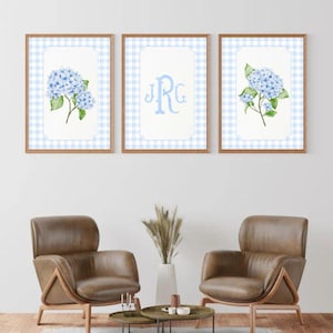 May include: Three framed prints with a blue and white gingham background. The center print features a monogram "JRG" in blue. The prints on either side feature a watercolor illustration of blue hydrangeas.