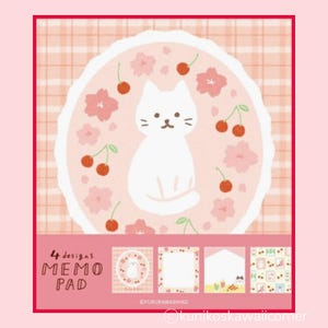 May include: A memo pad with four designs, featuring a white cat surrounded by pink cherry blossoms and cherries. The memo pad has a pink and white plaid background and the words "MEMO PAD" are visible.