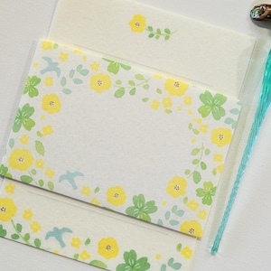 May include: A set of three blank note cards with a floral border. The border features yellow flowers, green leaves, and blue birds. The cards are perfect for writing letters, notes, or invitations.