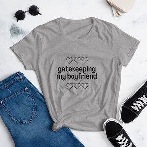 May include: Gray t-shirt with the text "gatekeeping my boyfriend" and hearts printed on it.