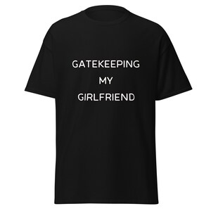 May include: Black t-shirt with white text that reads "GATEKEEPING MY GIRLFRIEND".