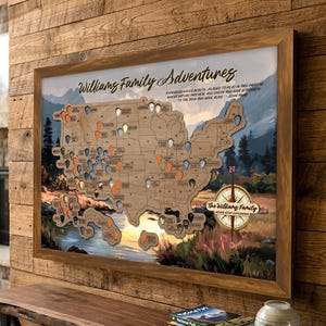 May include: A framed wooden map of the United States with colorful pins marking locations. The map is personalized with the text "Williams Family Adventures" and a quote. A compass graphic is in the lower right corner.