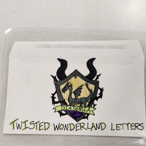 May include: A white envelope with a black and gold crest featuring a dragon and the text "Diasomnia". The envelope has the text "Twisted Wonderland Letters" written in green.