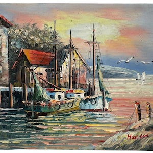 Peut inclure: Peinture à l'huile d'une scène de port avec des bateaux, des bâtiments et des mouettes. Les bateaux sont amarrés près de bâtiments aux toits rouges. Le ciel est un mélange de rose, de jaune et de bleu. Signé "Han tin" en bas à droite.