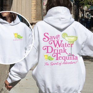 May include: White hoodie with a pink graphic that says "Save Water Drink Tequila The Spirit of Adventure!" and a picture of a margarita glass with a lime wedge. There is a smaller image of a shot glass and lime wedge on the front of the hoodie.