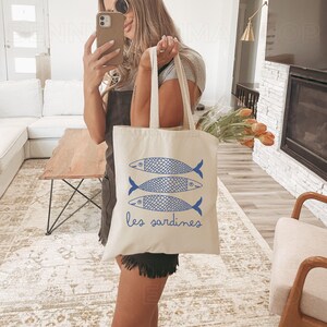 May include: A white canvas tote bag with blue illustrations of three sardines and the text "les sardines".