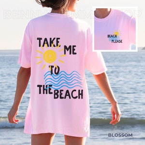 May include: Pink oversized t-shirt with a graphic design that says "Take me to the beach" with a sun and waves.