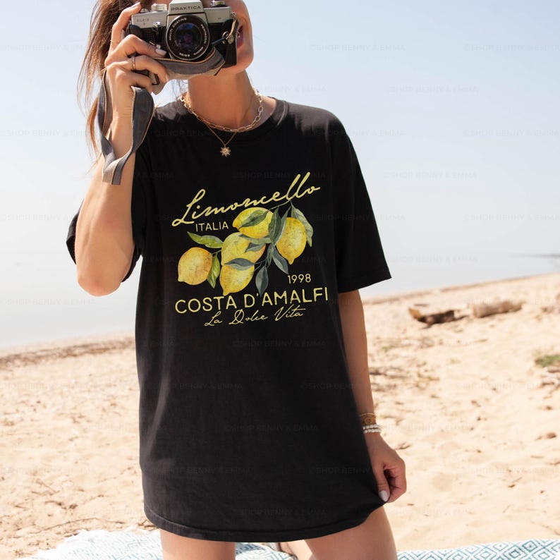 Puede incluir: Camiseta negra con un estampado gr&aacute;fico de limones y el texto "Limoncello Italia 1998 Costa D'Amalfi La Dolce Vita"