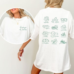 May include: White t-shirt with the text "always al dente" on the front and illustrations of different types of pasta on the back. The pasta types include: tagliatelle, farfalle, ravioli, rigatoni, ruote, pappardelle, cavatelli, gnocchi, maccheron, conchigliette, orecchiette, and penne.