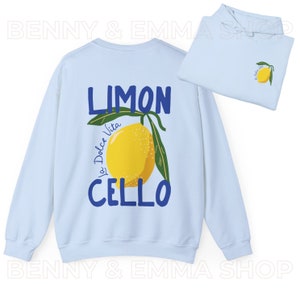 May include: Light blue sweatshirt with a lemon graphic and the text "Limoncello La Dolce Vita" in blue lettering.