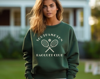 May include: A forest green sweatshirt with a white graphic design of two tennis rackets crossed with a tennis ball in the center. The text "Southampton Racquet Club" is printed below the rackets.