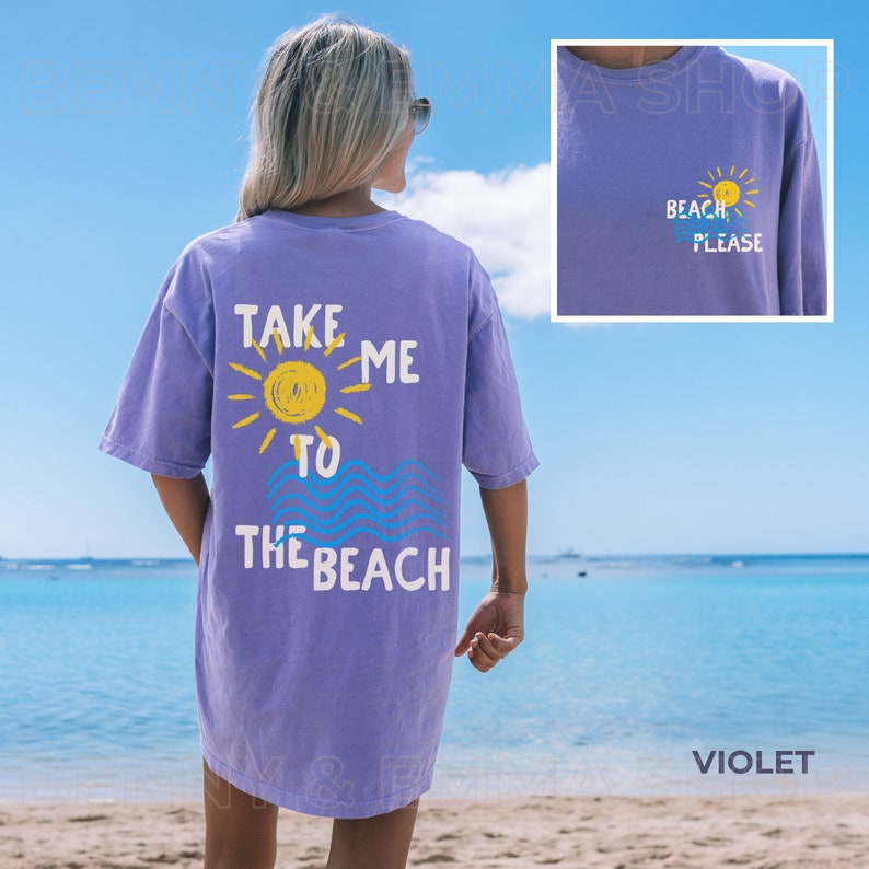 May include: A purple t-shirt with the text "Take Me To The Beach" and a sun and waves graphic on the back. The front of the shirt has the text "Beach Please" and a sun graphic.