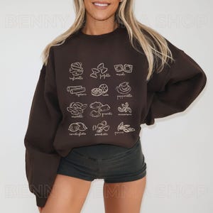 May include: A brown sweatshirt with a white graphic of different types of pasta, including tagliatelle, farfalle, rigatoni, and more.