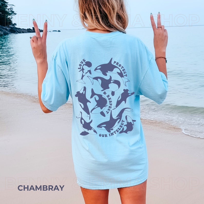 May include: A light blue t-shirt with a graphic of orcas and the text "Love, Protect & Respect Our Intellect" printed on the back.
