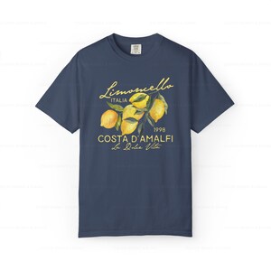 Puede incluir: Una camiseta azul marino con un gr&aacute;fico de limones y el texto "Limoncello Italia 1998 Costa D'Amalfi La Dolce Vita".
