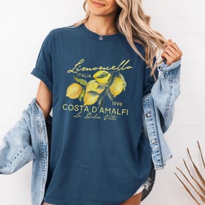 Puede incluir: Una camiseta azul marino con un gr&aacute;fico de limones y el texto "Limoncello Italia 1998 Costa d'Amalfi La Dolce Vita".