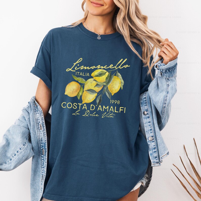 Puede incluir: Una camiseta azul marino con un gr&aacute;fico de limones y el texto "Limoncello Italia 1998 Costa d'Amalfi La Dolce Vita".