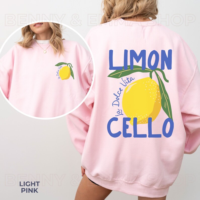 May include: A light pink sweatshirt with a lemon graphic and the text "Limon Cello La Dolce Vita" printed on the back.