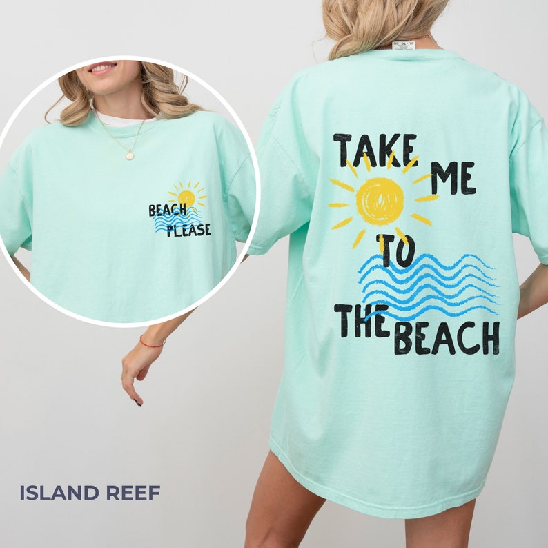 May include: A light blue t-shirt with the text "Take me to the beach" on the back. The text is in black with a yellow sun and blue waves. The front of the shirt has the text "Beach Please" in black with a yellow sun and blue waves.