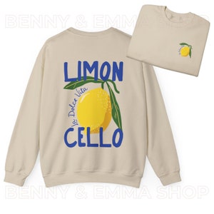 May include: A beige sweatshirt with a blue and yellow lemon graphic and the text "LIMON La Dolce Vita CELLO" printed on the back.