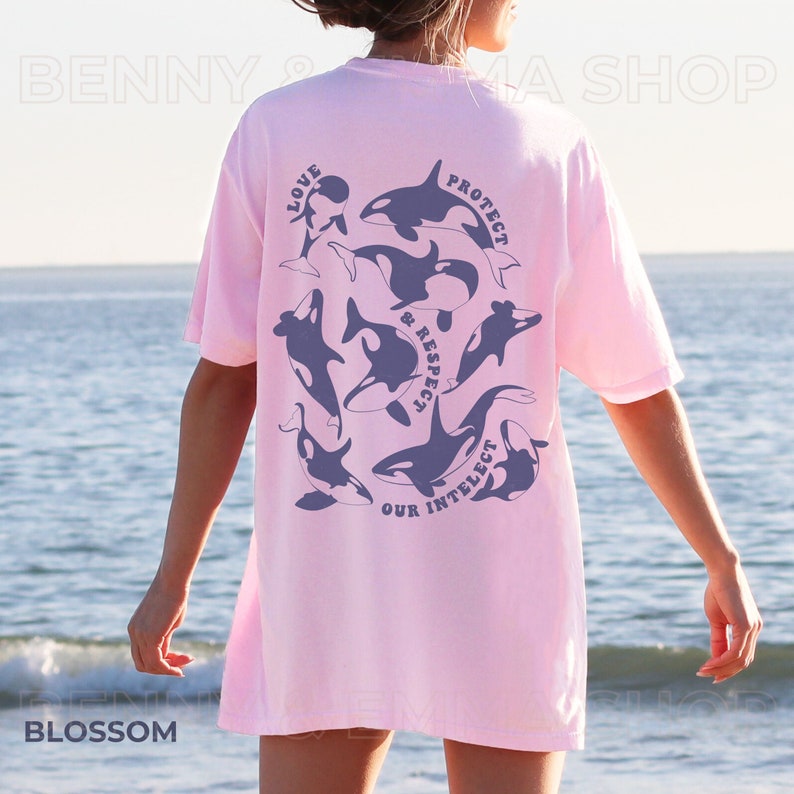 May include: Pink t-shirt with a graphic of orcas and the text "Love, Protect & Respect Our Intellect".