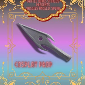 Op de afbeelding: Een grijze cosplay speer prop met een puntige punt en een cirkelvormig gat. De afbeelding bevat de tekst "Battle Works Studios Presents Vaggies Angelic Spear" en "Cosplay Prop" op een verloopachtergrond.
