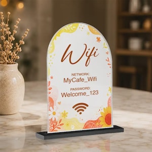 May include: An arched acrylic sign with a black base featuring a floral design in yellow, orange, and white. The text reads Wifi, NETWORK: MyCafe_Wifi, and PASSWORD: Welcome_123, accompanied by a brown wifi signal icon at the bottom centre.