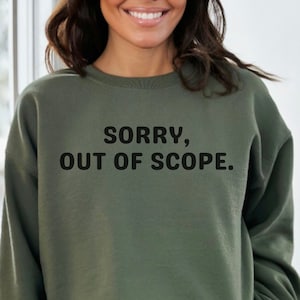 May include: A green sweatshirt with the text "SORRY, OUT OF SCOPE." printed in black.