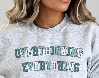 May include: Gray sweatshirt with the text "Overthinking Everything" in green and white lettering.